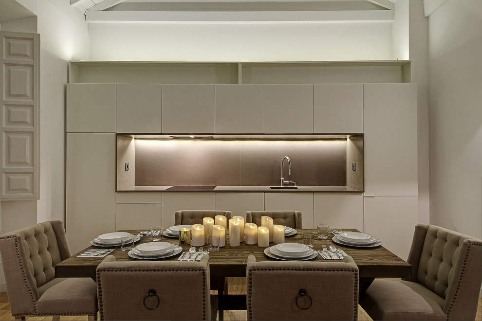 Ispirazione per una sala da pranzo aperta verso la cucina minimal di medie dimensioni con pareti bianche, pavimento in legno massello medio e pavimento beige