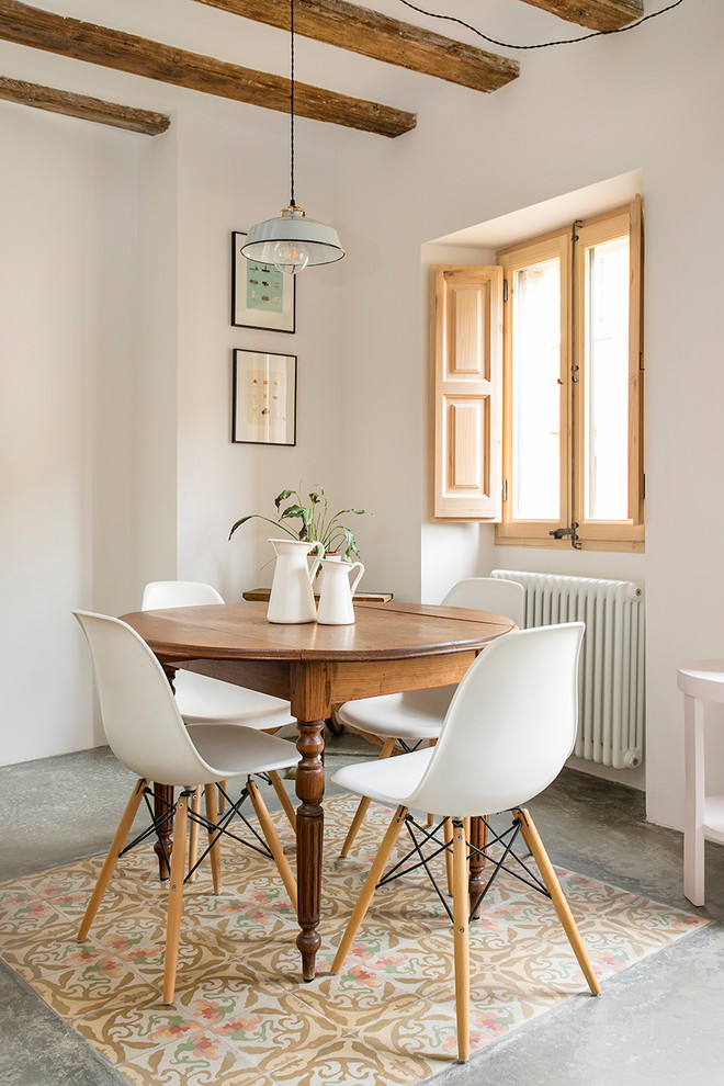 Idee per una sala da pranzo mediterranea con pareti bianche, pavimento in cemento e pavimento grigio