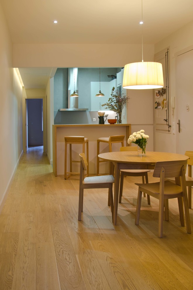 Immagine di una piccola sala da pranzo aperta verso la cucina mediterranea con pareti bianche, pavimento in legno massello medio e nessun camino