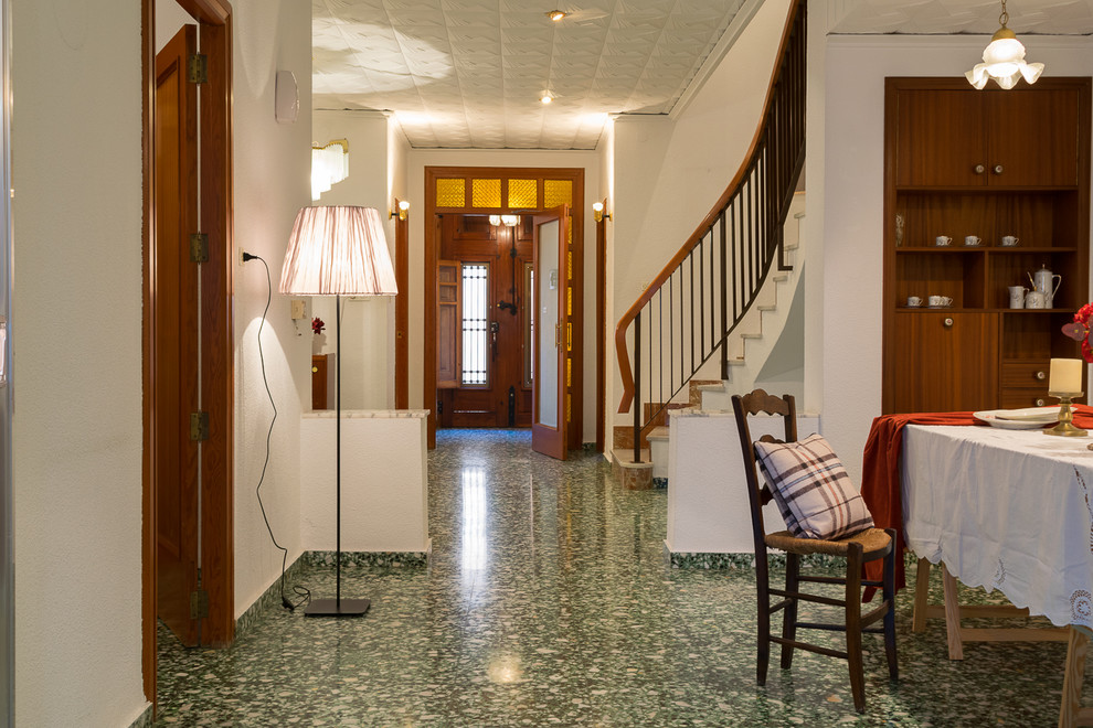 Idee per una sala da pranzo aperta verso il soggiorno mediterranea con camino classico, cornice del camino in mattoni e pavimento verde