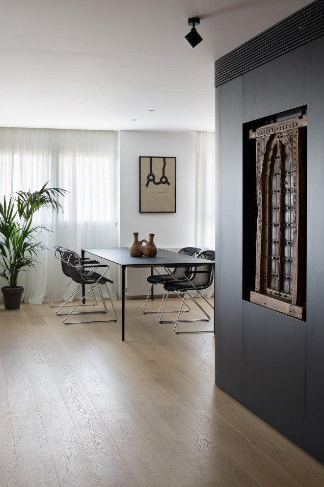 Foto di una grande sala da pranzo aperta verso il soggiorno design con pareti nere, pavimento in legno massello medio e pavimento marrone