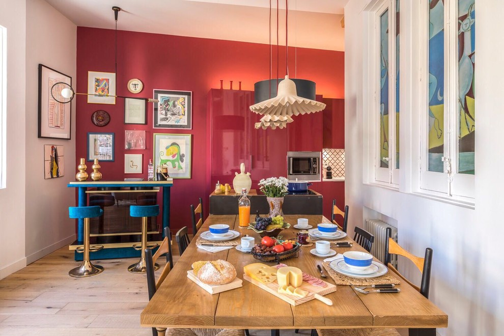 Ejemplo de comedor de cocina ecléctico con paredes rojas y suelo de madera clara