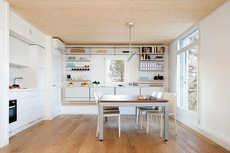 Cette image montre une salle à manger ouverte sur la cuisine nordique de taille moyenne avec un mur blanc, un sol en bois brun et aucune cheminée.