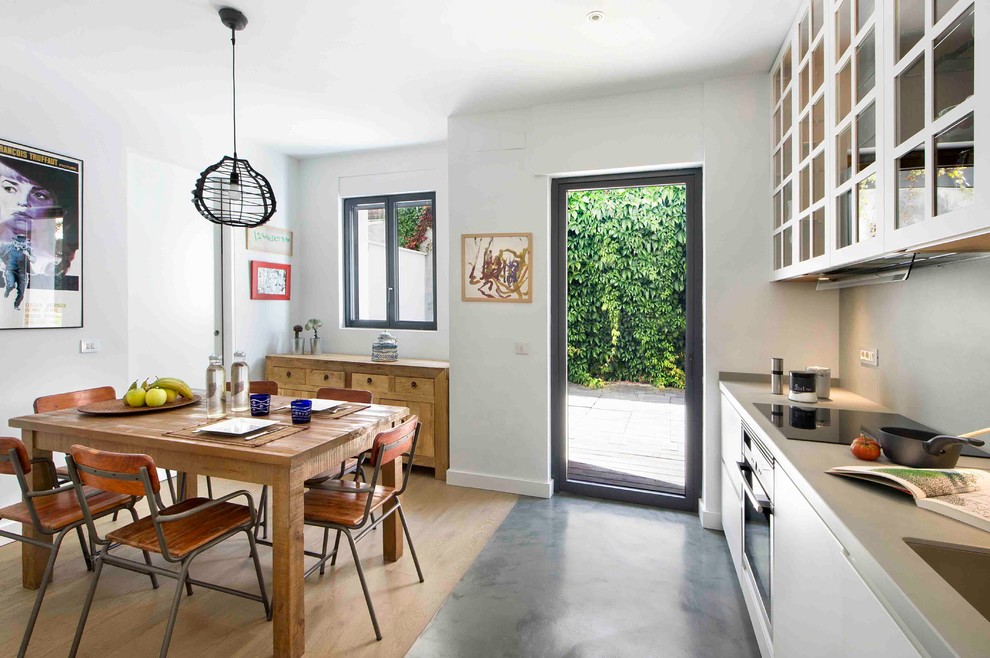 Foto de comedor de cocina actual de tamaño medio sin chimenea con paredes blancas y suelo de madera en tonos medios