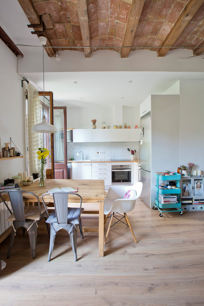 Foto de comedor de cocina escandinavo de tamaño medio sin chimenea con paredes blancas, suelo de madera clara y suelo beige