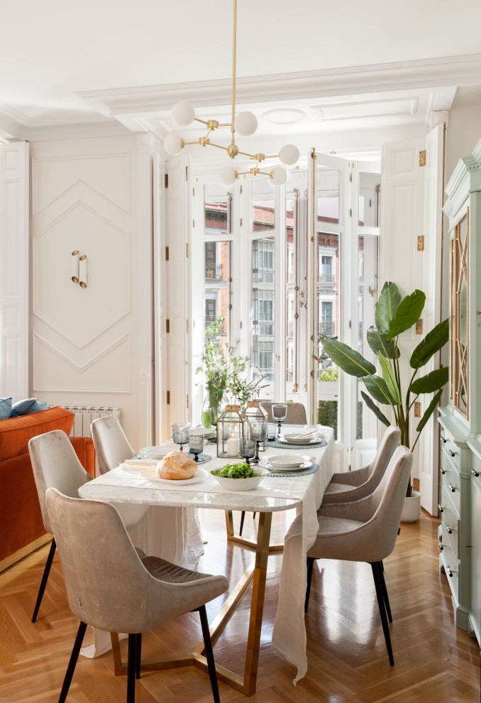 Immagine di una sala da pranzo aperta verso il soggiorno contemporanea con pareti bianche, parquet chiaro, pavimento marrone e pannellatura