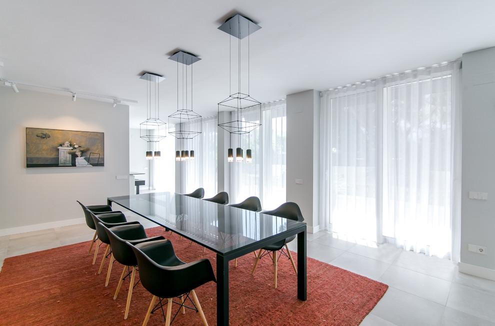 Idee per una grande sala da pranzo aperta verso il soggiorno design con pareti grigie, pavimento in gres porcellanato e pavimento grigio