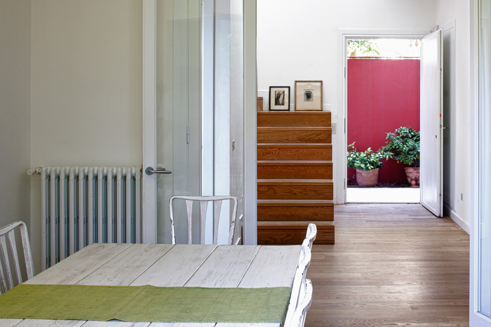 Ispirazione per una grande sala da pranzo aperta verso la cucina eclettica con pareti bianche, pavimento in legno massello medio e pavimento marrone
