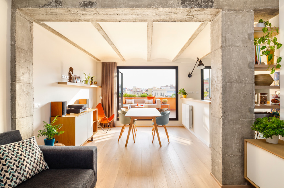 Example of a mid-sized trendy medium tone wood floor and brown floor great room design in Barcelona with white walls and no fireplace