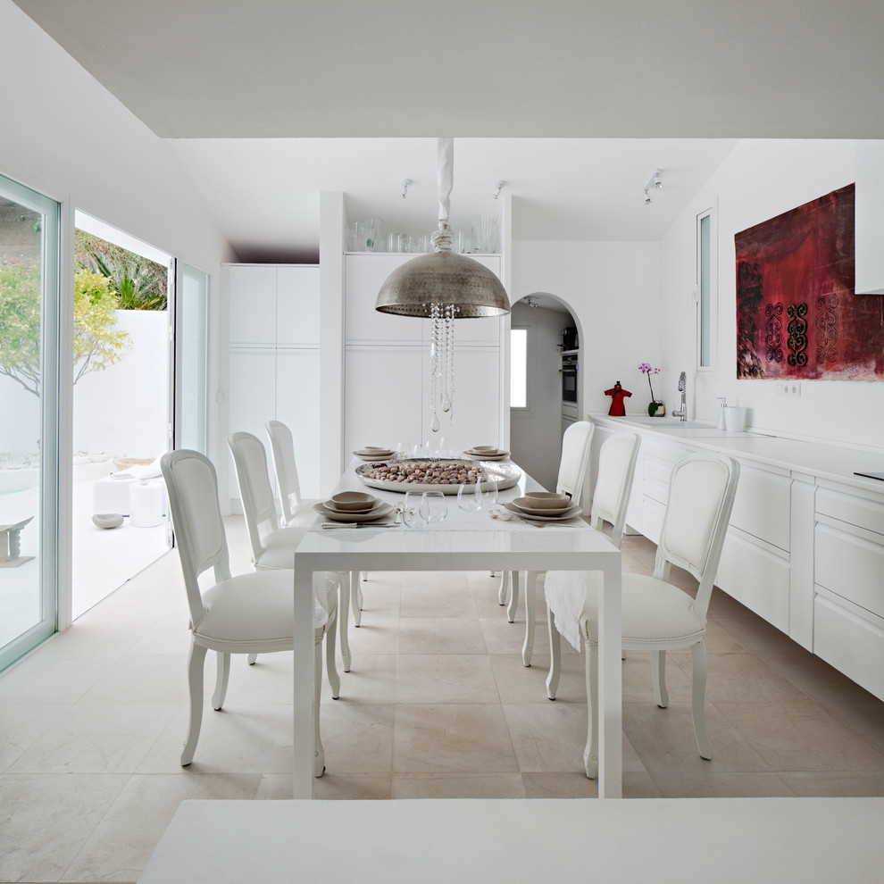 Cette image montre une grande salle à manger ouverte sur la cuisine méditerranéenne avec un mur blanc, un sol en travertin, aucune cheminée et un sol beige.