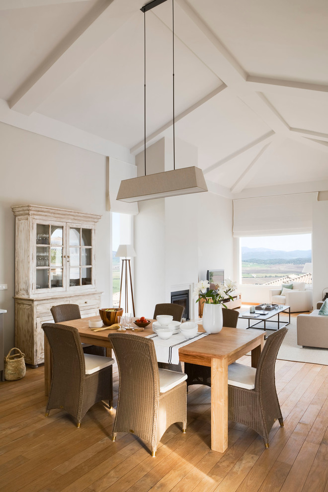 Inspiration for a large mediterranean medium tone wood floor great room remodel in Malaga with beige walls and no fireplace