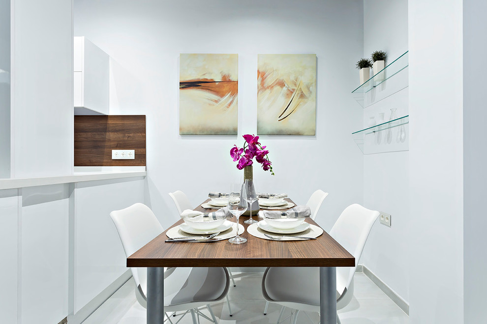 Exemple d'une salle à manger tendance avec un mur blanc et un sol blanc.