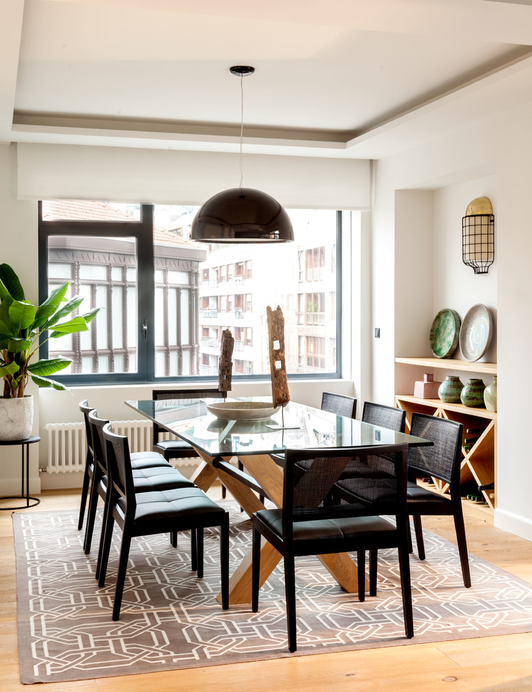 Immagine di una sala da pranzo design con pareti bianche, pavimento in legno massello medio e pavimento marrone