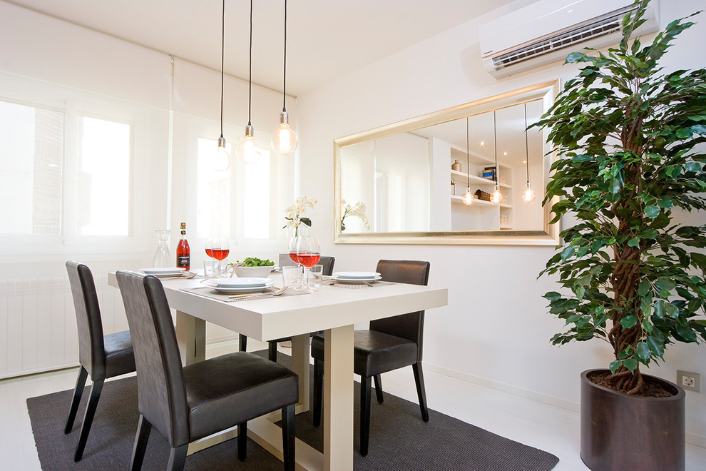 Cette image montre une salle à manger ouverte sur le salon design de taille moyenne avec un mur blanc, parquet clair et un sol blanc.