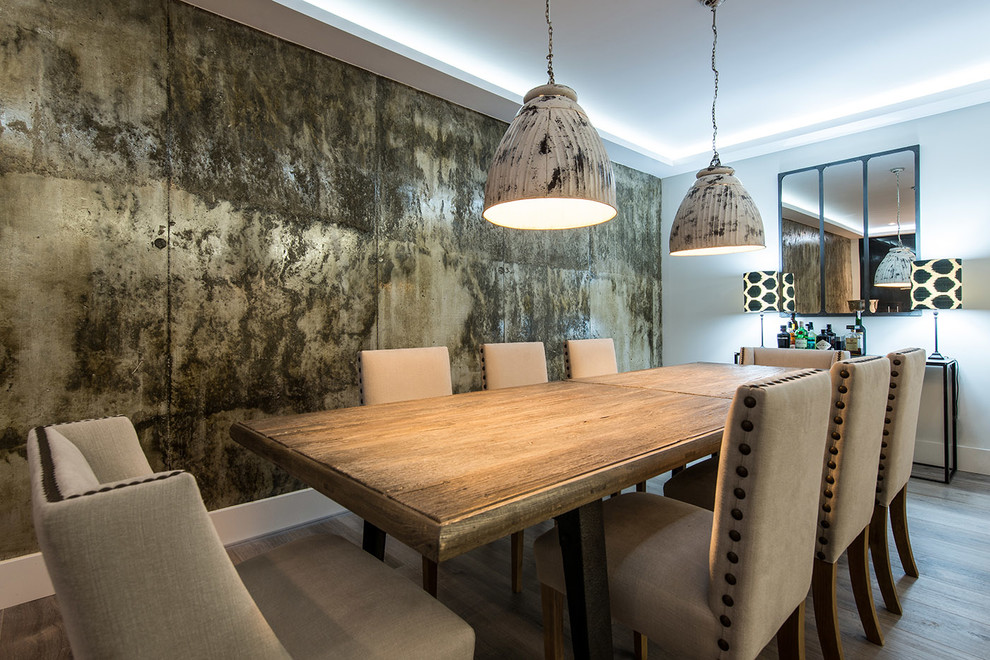 Cette photo montre une grande salle à manger ouverte sur le salon tendance avec un sol en bois brun, aucune cheminée, mur métallisé et éclairage.