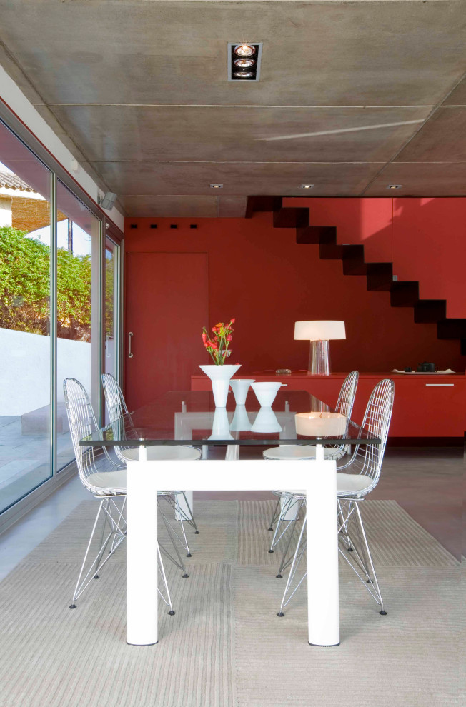 Cette image montre une grande salle à manger ouverte sur le salon design avec un mur rouge, un sol en carrelage de porcelaine et un sol gris.