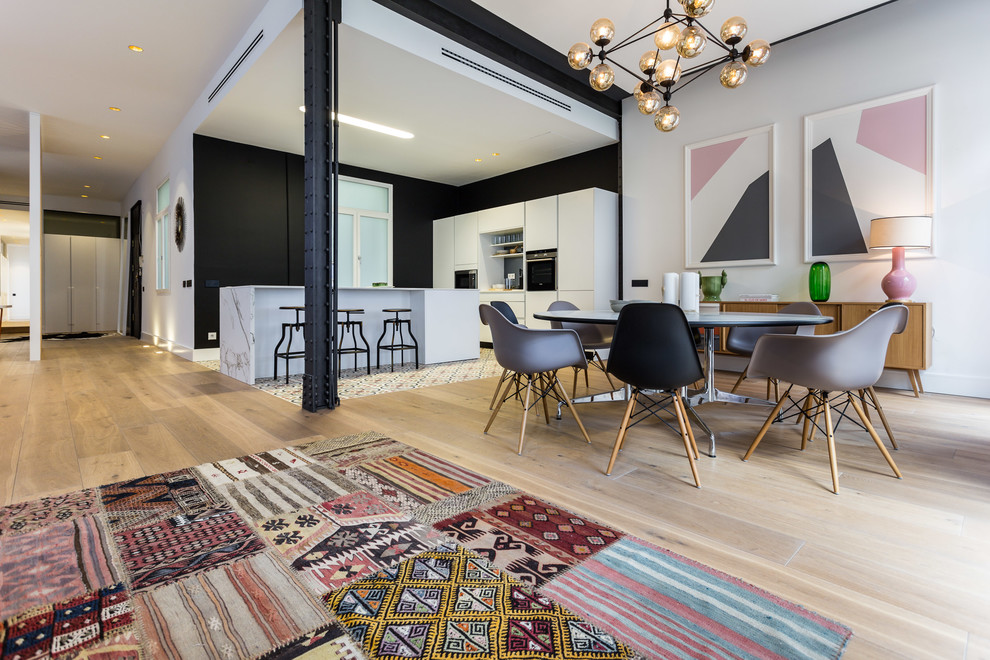 Cette photo montre une grande salle à manger ouverte sur le salon tendance avec un mur blanc, parquet clair et aucune cheminée.