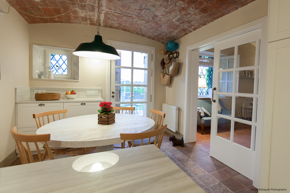 Foto di una sala da pranzo aperta verso la cucina mediterranea di medie dimensioni con pareti beige, pavimento in terracotta e nessun camino