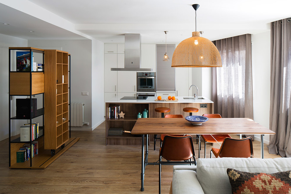 Mittelgroße Klassische Wohnküche ohne Kamin mit weißer Wandfarbe und braunem Holzboden in Barcelona