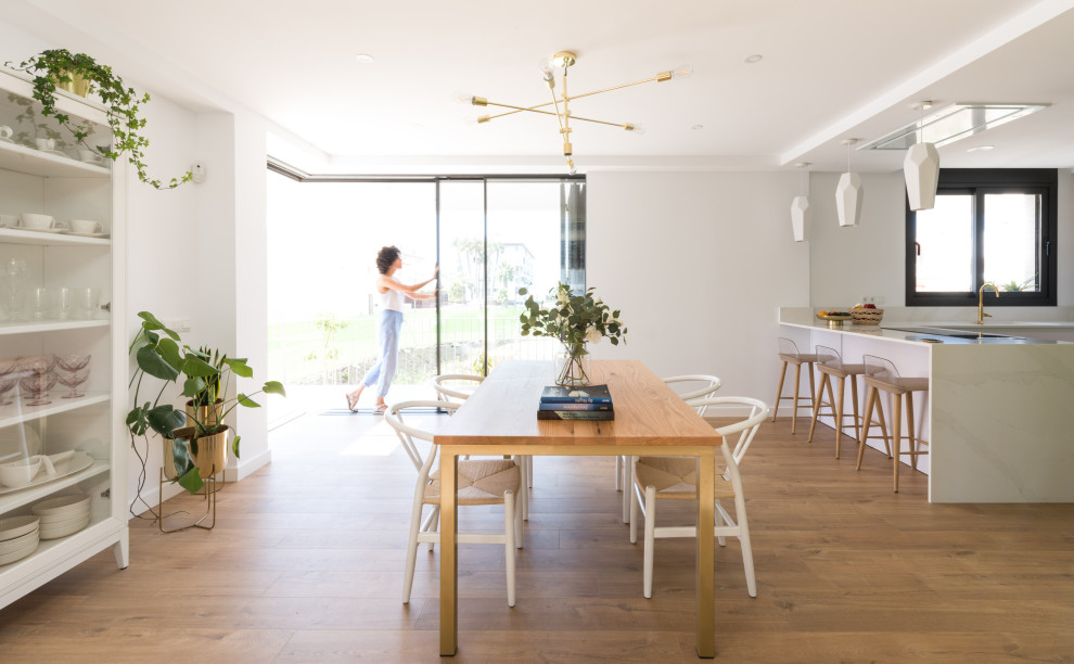Mittelgroße Moderne Wohnküche ohne Kamin mit weißer Wandfarbe und Laminat in Madrid