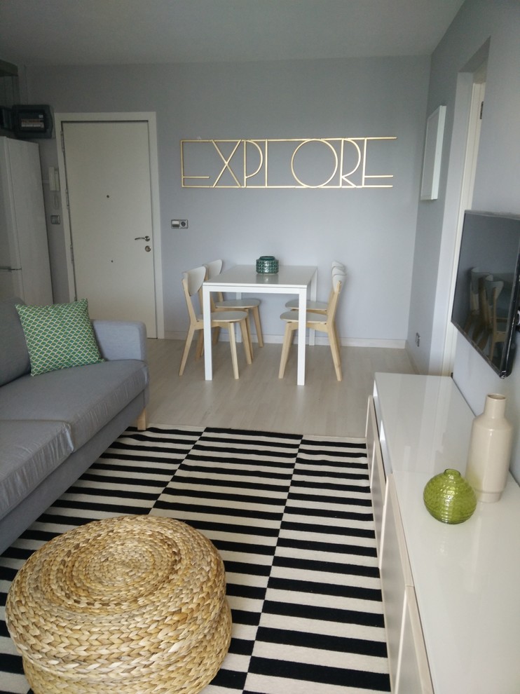Idee per una sala da pranzo aperta verso il soggiorno minimal di medie dimensioni con pareti grigie, parquet chiaro e pavimento beige