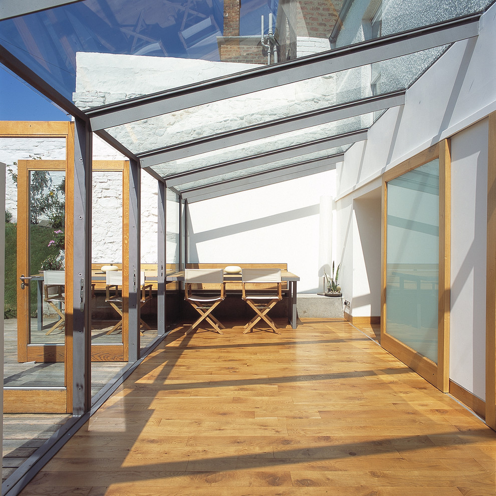 Foto de galería actual grande con suelo de madera clara y techo de vidrio
