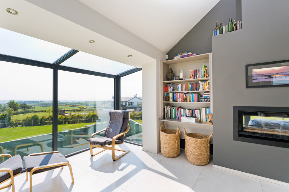This is an example of a medium sized contemporary conservatory in Belfast with porcelain flooring and a two-sided fireplace.