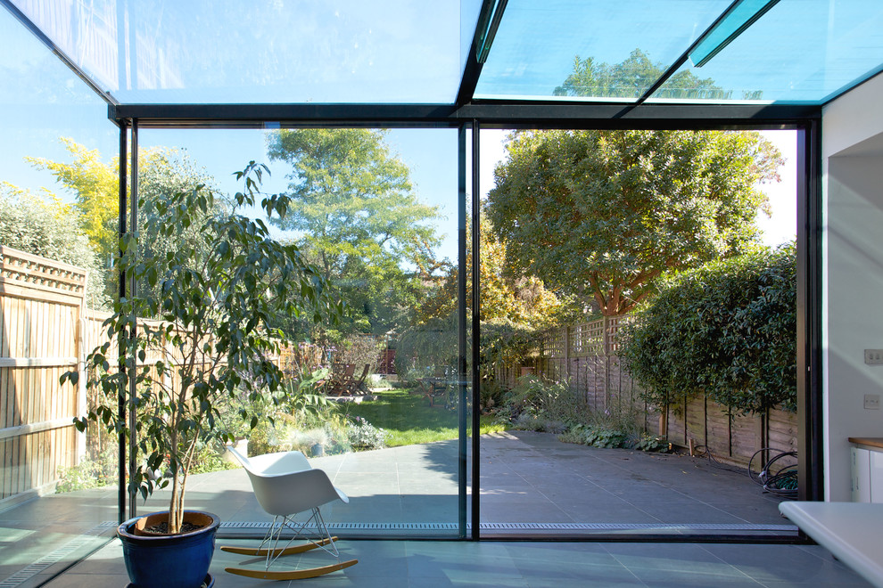 Immagine di una veranda minimal di medie dimensioni con pavimento in ardesia, soffitto in vetro e pavimento grigio