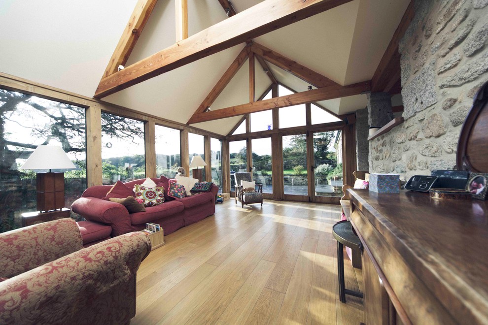 Diseño de galería de estilo de casa de campo grande sin chimenea con suelo de madera en tonos medios y techo estándar