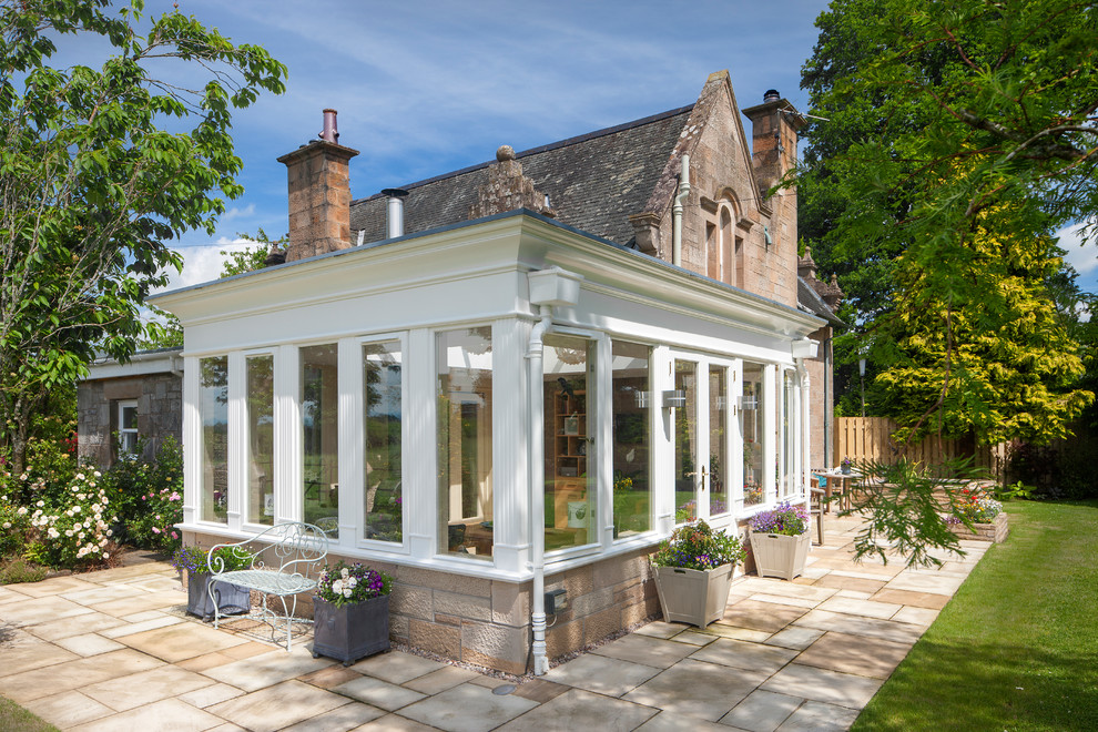 Inspiration for a large traditional conservatory in Edinburgh with travertine flooring, a wood burning stove, a plastered fireplace surround, a skylight and beige floors.