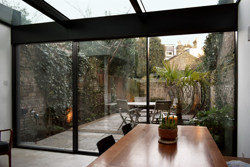 Design ideas for a medium sized modern conservatory in London with concrete flooring, a glass ceiling and grey floors.