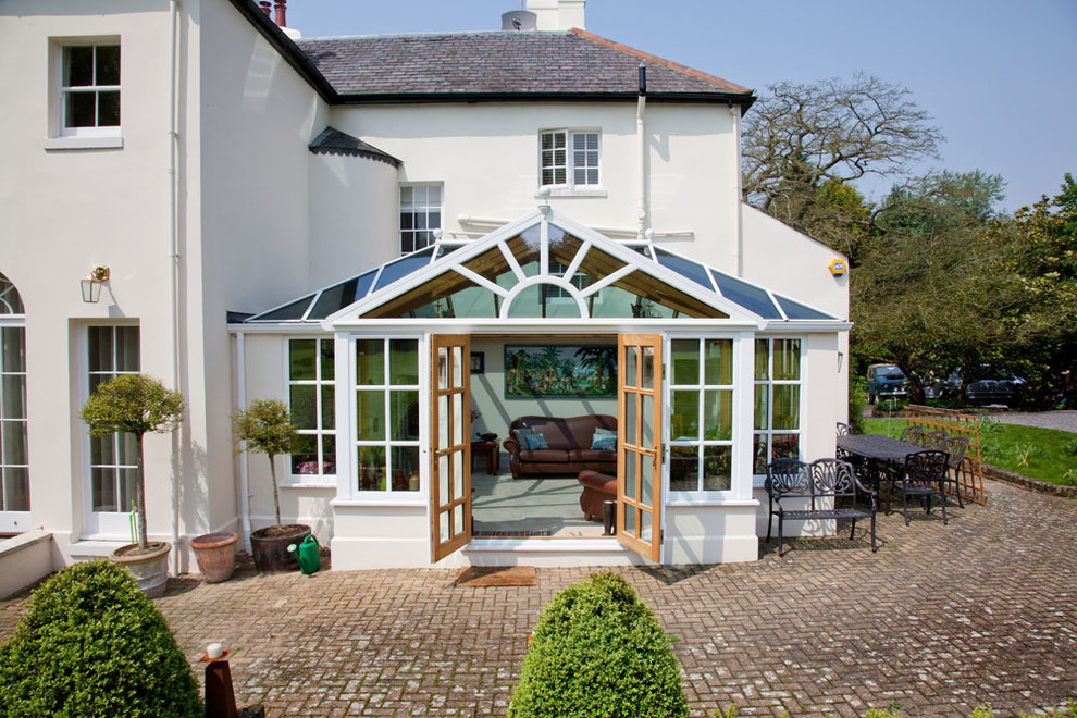 Example of a large classic sunroom design in Sussex with a glass ceiling