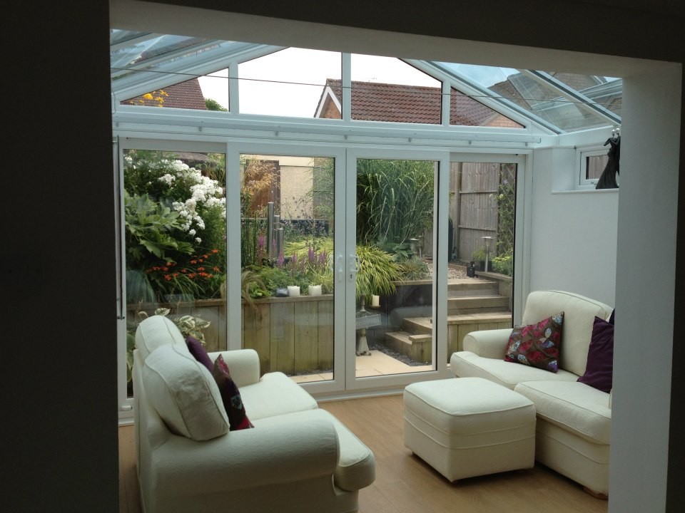 Medium sized traditional conservatory in Surrey with light hardwood flooring and a glass ceiling.