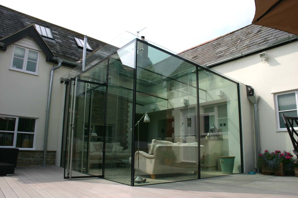 Small contemporary conservatory in Wiltshire with limestone flooring and a glass ceiling.