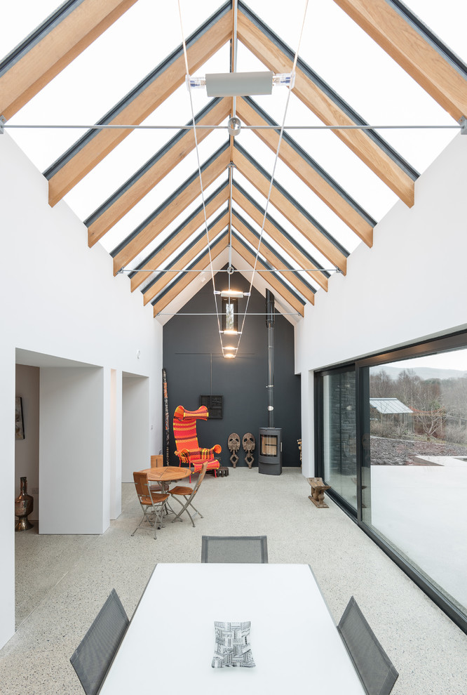 Esempio di una veranda design con soffitto in vetro e pavimento grigio