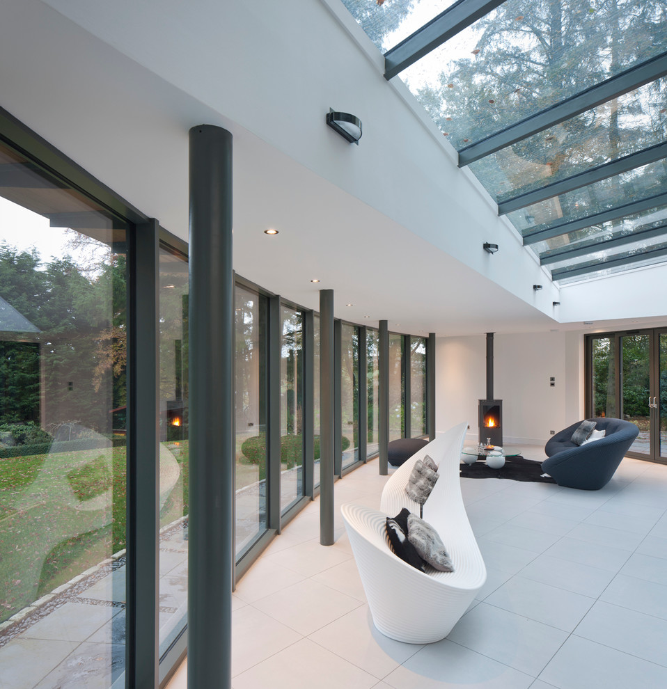 Inspiration för mellanstora moderna uterum, med klinkergolv i porslin, takfönster och en öppen vedspis