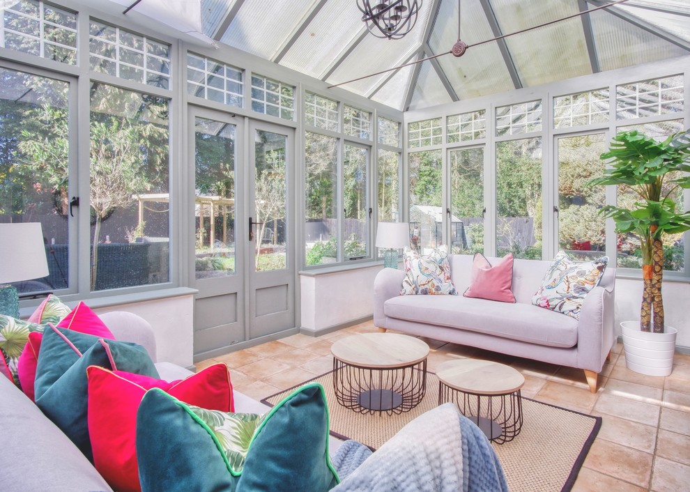 This is an example of a medium sized traditional conservatory in Cambridgeshire with ceramic flooring, no fireplace, a glass ceiling and red floors.