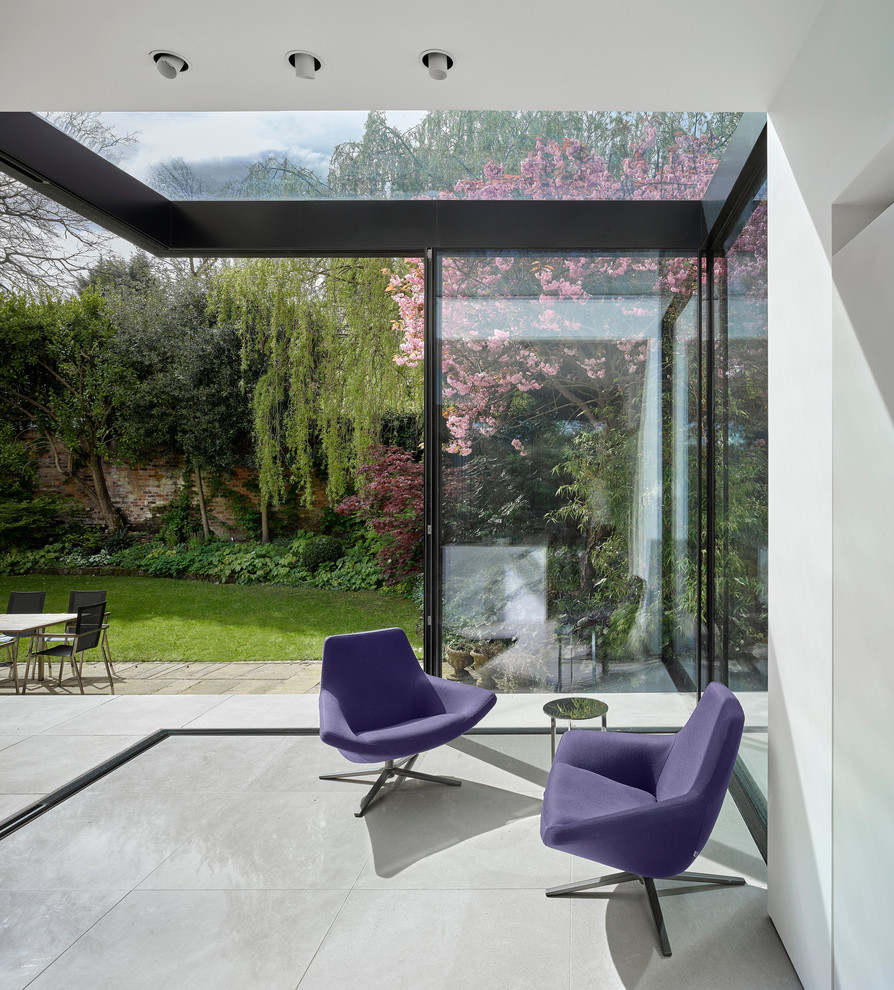 This is an example of a medium sized contemporary conservatory in Manchester with a glass ceiling and grey floors.