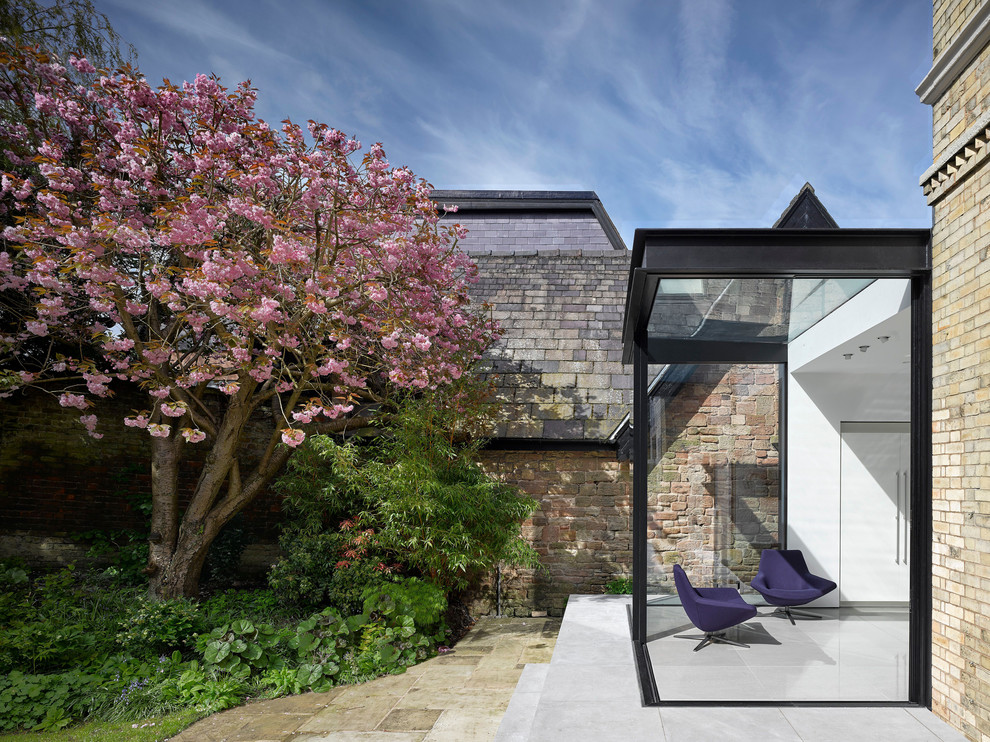 Immagine di una piccola veranda minimal con pavimento in ardesia, soffitto in vetro e pavimento grigio