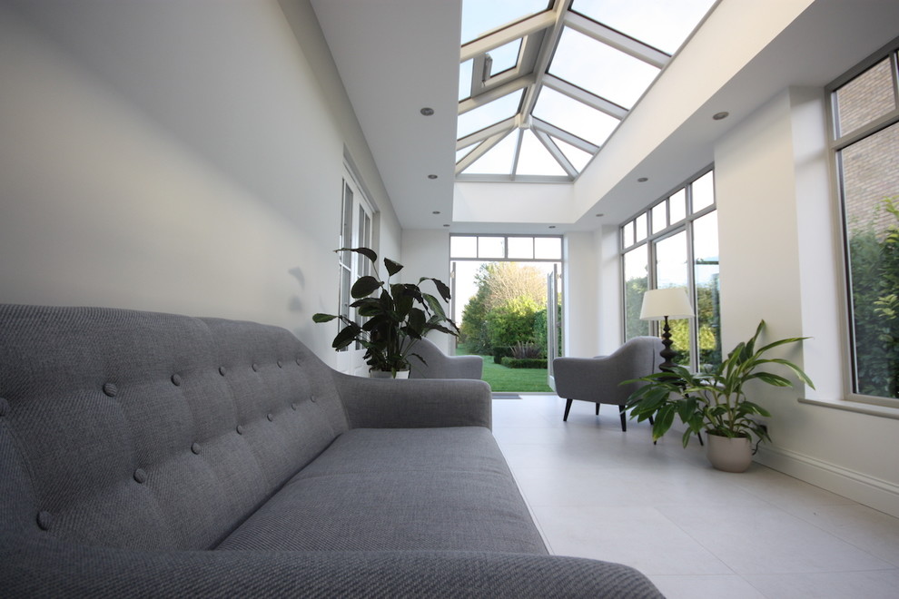Design ideas for a medium sized contemporary conservatory in Cambridgeshire with porcelain flooring, a glass ceiling and grey floors.