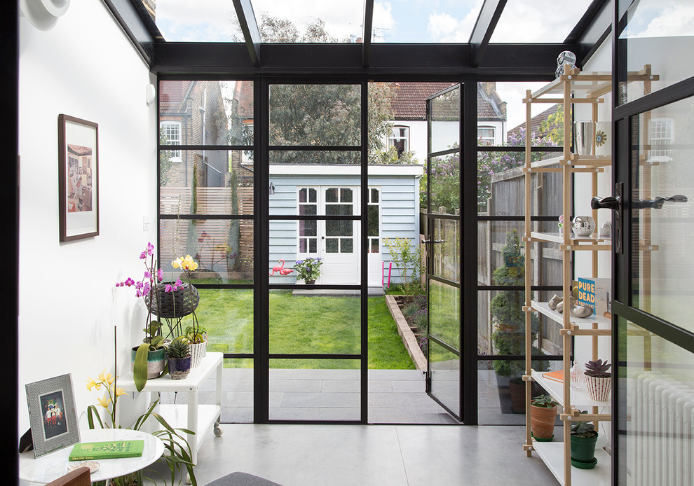 Small scandinavian conservatory in London with no fireplace, a glass ceiling, concrete flooring and grey floors.