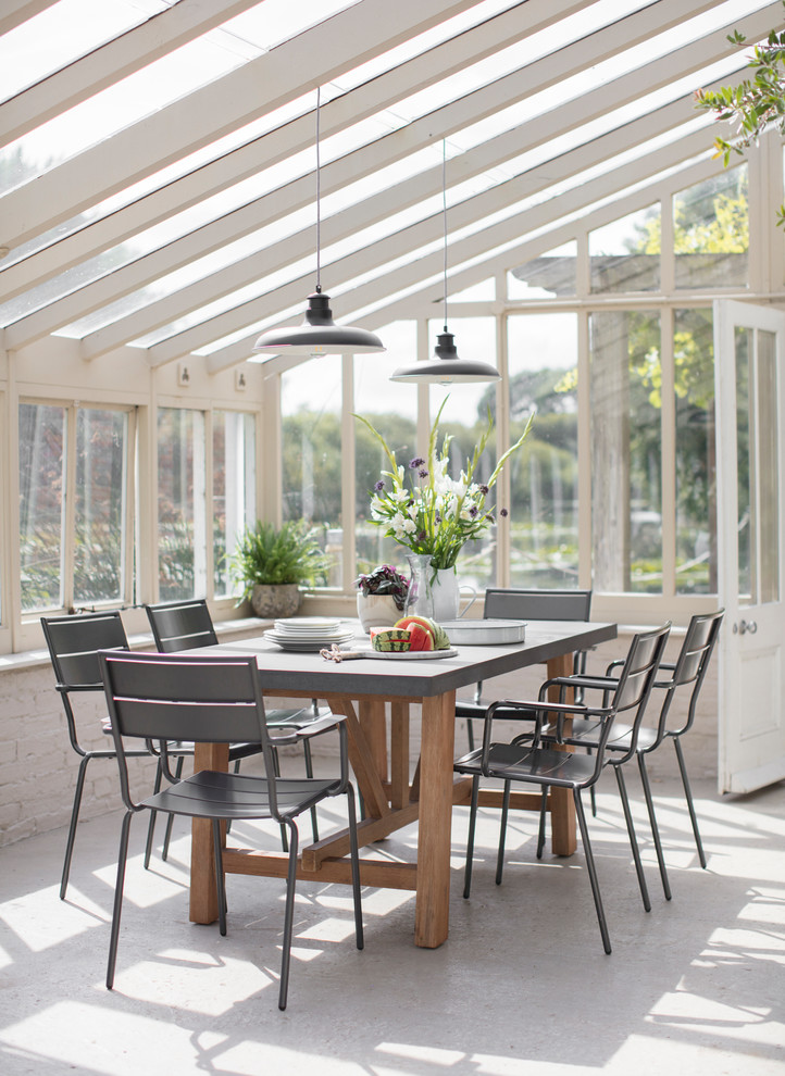 This is an example of a rural conservatory in Oxfordshire with a glass ceiling and beige floors.