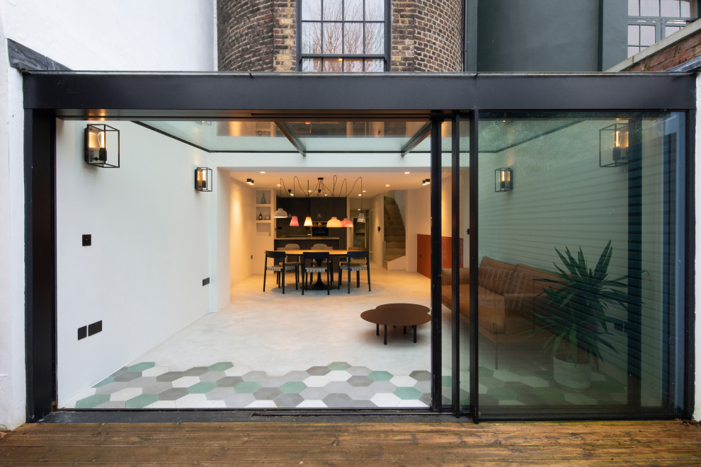 Immagine di una veranda minimalista di medie dimensioni con pavimento in cemento, soffitto in vetro e pavimento grigio
