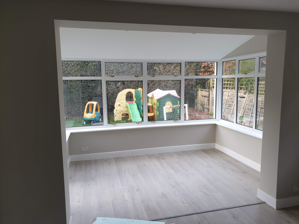 Idee per una veranda moderna con pavimento in laminato, soffitto classico e pavimento grigio