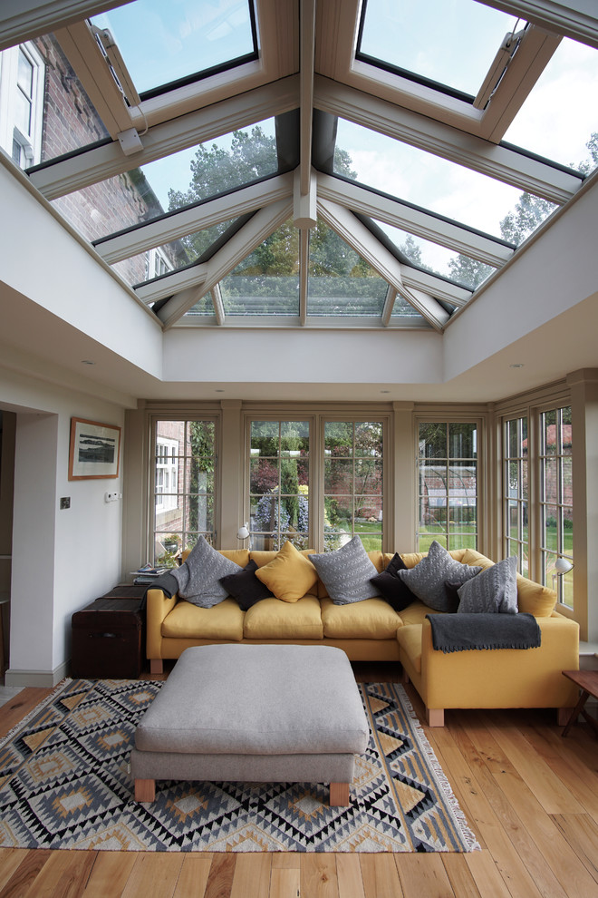Foto di una veranda chic con parquet chiaro, soffitto in vetro e pavimento marrone