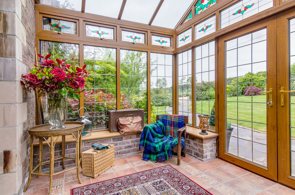 Immagine di una veranda country con pavimento in terracotta e soffitto in vetro