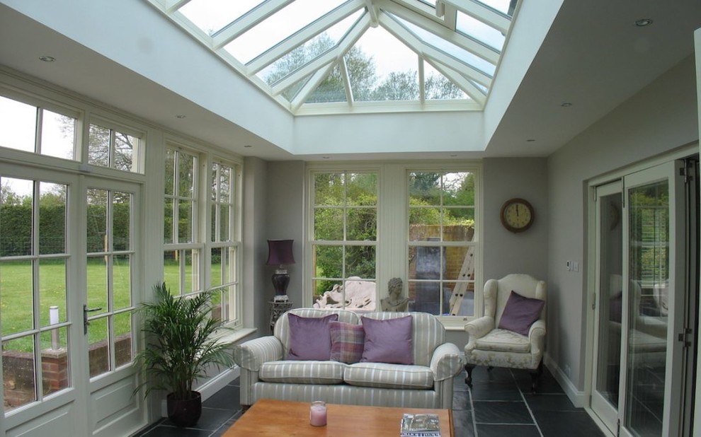 Idee per una grande veranda classica con pavimento in ardesia, soffitto in vetro e pavimento grigio