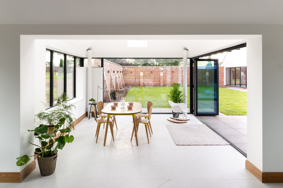 Immagine di una grande veranda minimal con pavimento in gres porcellanato, lucernario e pavimento bianco