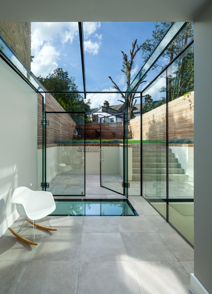 Стильный дизайн: терраса в стиле модернизм с бетонным полом, стеклянным потолком и серым полом - последний тренд