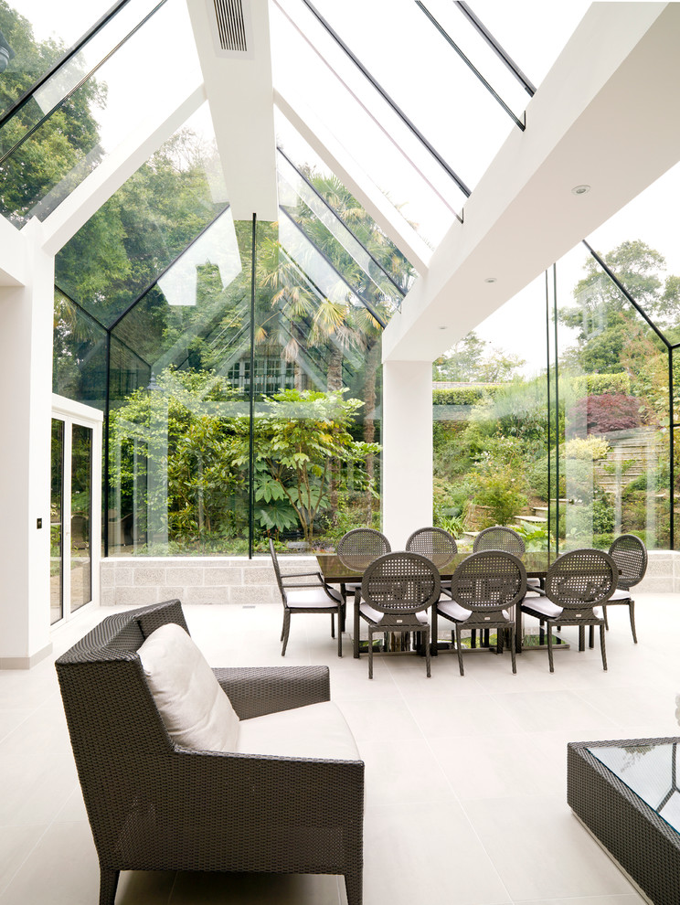 Ispirazione per una grande veranda design con pavimento in pietra calcarea, soffitto in vetro e pavimento beige
